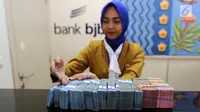 Petugas teller Bank BJB menghitung uang di kantor Bank BJB Cabang Kebayoran Baru, Jakarta Selatan. (Liputan6.com/Fery Pradolo