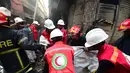 Petugas penyelamat membawa jenazah korban setelah kebakaran di gedung apartemen di Dhaka (21/2). Setidaknya 69 orang tewas dalam kebakaran besar yang melanda gedung  yang juga digunakan sebagai gudang bahan kimia. (AFP Photo/Munir Uz Zaman)