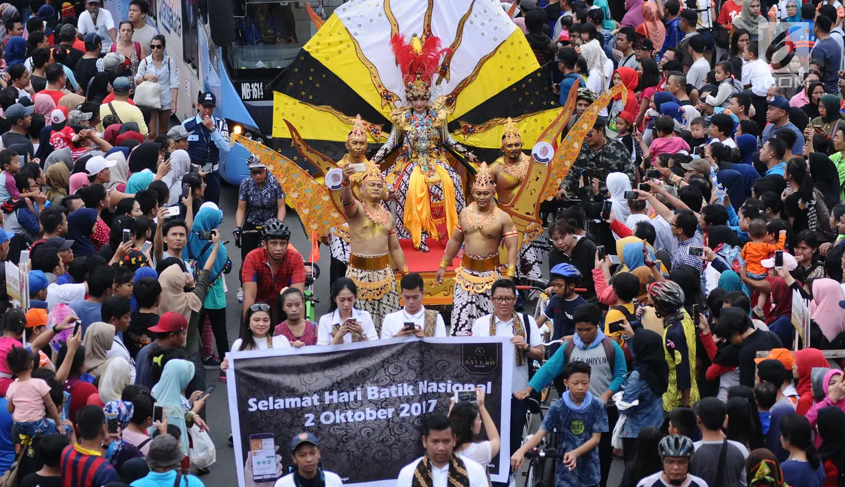 Peserta pawai perayaan Hari Batik Nasional berusaha menembus kerumunan warga saat Hari Bebas Kendaraan di kawasan Bundaran HI, Jakarta, Minggu (1/10). Parade Batik Nusantara ini perayaan Hari Batik Nasional 2 Oktober. (Liputan6.com/Helmi Fithriansyah)