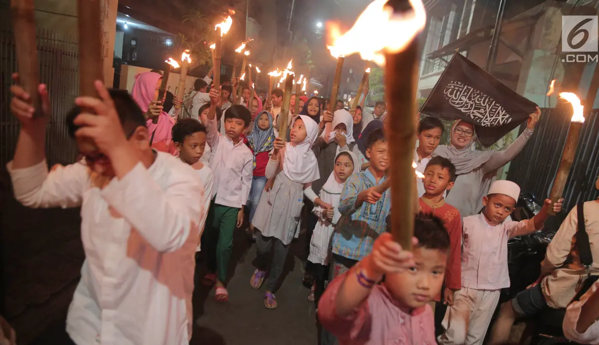 Anak-anak mengikuti pawai obor menyambut Tahun Baru Islam 1 Muharam 1439 Hijriah kawasan Cikini, Jakarta, Rabu (20/9). Mereka berkeliling sambil bersalawat dengan membawa obor dan alat musik. (Liputan6.com/Faizal Fanani)