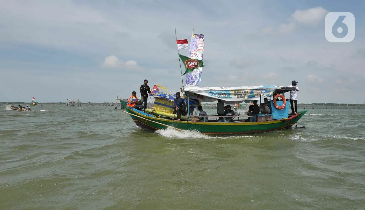 Sejumlah nelayan bersiap untuk melarung replika kapal berisi sesaji di Pantai Tarumajaya, Kabupaten Bekasi, Jawa Barat, Jumat (28/1/2022). Ritual ini diikuti sebanyak 40 kapal nelayan dari enam Muara. (Liputan6.com/Herman Zakharia)