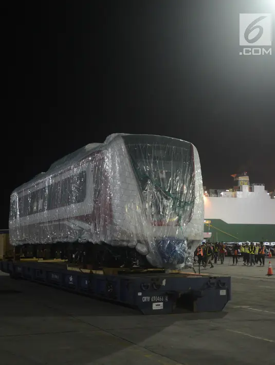 Pekerja dibantu alat berat menarik gerbong kereta ringan/Light Rail Transit (LRT) di Pelabuhan Car Terminal, Tanjung Priok, Jakarta, Jumat (13/4). Gerbong ini akan langsung diangkut menuju Dipo LRt di Kelapa Gading.  (Merdeka.com/Imam Buhori)
