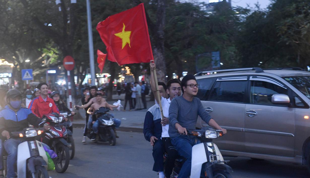 Sejumlah warga konvoi merayakan keberhasilan Vietnam mengalahkan Qatar pada semifinal Piala AFC U-23 di Hanoi, Rabu (23/1/2018). Vietnam berhasil lolos ke final untuk menantang pemenang antara Uzbekistan dan Korea Selatan. (AFP/Hoang Dinh Nam)