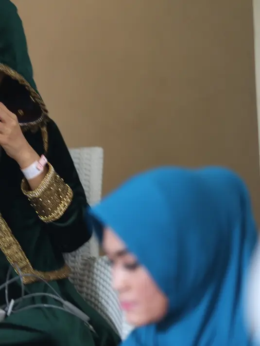 Dengan wajah yang masih terlihat pucat, Julia Perez menyempatkan hadir dalam pengajian yang dilakukan oleh keluarganya. Dengan tertatih sambil dipapah, ia memasuki kediaman ibundanya. (Nurwahyunan/Bintang.com)