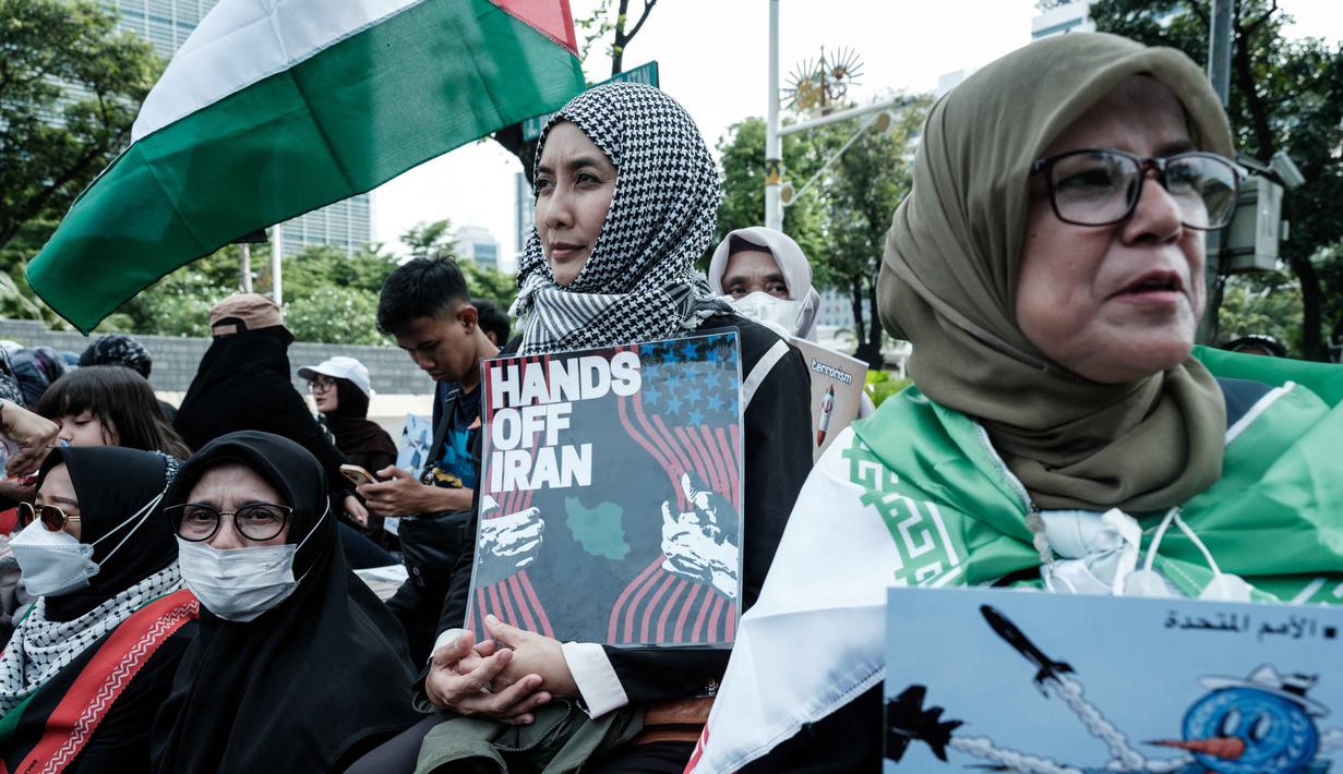 Aksi tersebut sebagai respons terhadap eskalasi konflik yang melibatkan Amerika Serikat dan Israel terhadap Republik Islam Iran. Tampak dalam foto, warga berunjuk rasa menentang serangan gabungan Amerika Serikat (AS)-Israel terhadap Iran dan berduka atas gugurnya pemimpin tertinggi Iran, Ayatollah Ali Khamenei, di depan Kedutaan Besar Amerika Serikat di Jakarta pada Senin 9 Maret 2026. (YASUYOSHI CHIBA/AFP)