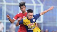 Vikrian Akbar (Biru) beduel dengan seniornya, Jayus Hariono dalam uji coba Arema FC versus Arema U-21 pada Minggu (16/6/2019) di Stadion Kanjuruhan, Kab. Malang. (Bola.com/Iwan Setiawan)