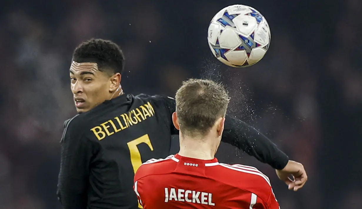 Pemain Real Madrid, Jude Bellingham (kiri) berebut bola dengan pemain Union Berlin, Paul Jaeckel pada laga lanjutan Grup C Liga Champions 2023/2024 di Olympiastadion, Berlin, Jerman, Rabu (13/12/2023) dini hari WIB. (AFP/Odd Andersen)