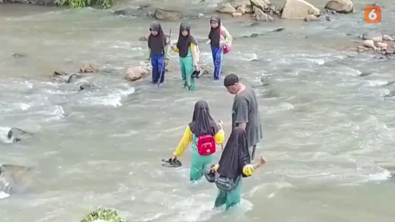 Pelajar SD Negeri Cibadak, Neglasari, Kecamatan Lengkong saat sebrangi sungai Cikaso menuju sekolah. (Liputan6.com/Fira Syahrin).