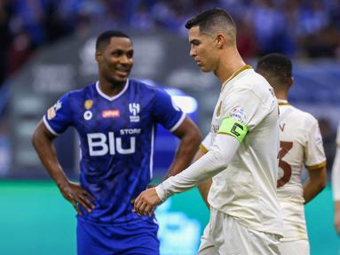 Pemain Al-Nassr, Cristiano Ronaldo, tertunduk lesu setelah ditaklukkan Al-Hilal pada laga Liga Arab Saudi 2022/202 di Stadion King Fahd, Rabu (19/4/2023). Mantan striker Manchester United (MU) Odion Ighalo menjadi bintang kemenangan Al Hilal. (AFP/Fayez Nureldine)