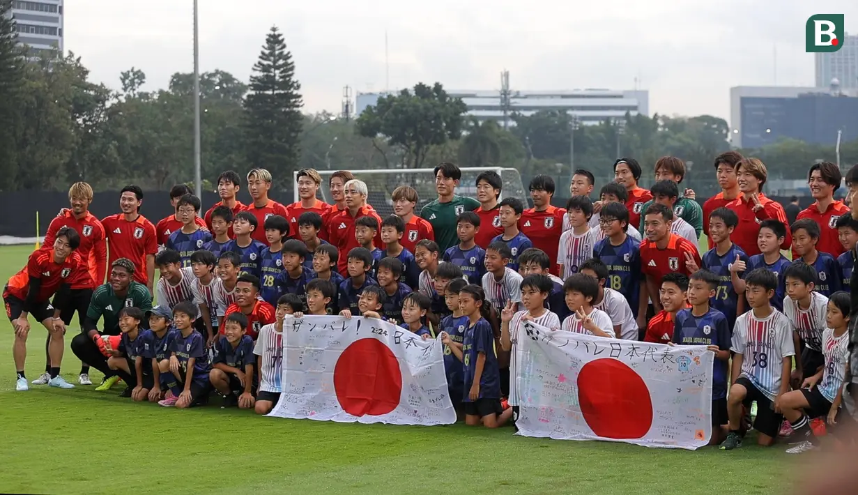 Sejumlah anak-anak yang tergabung ke dalam sekolah sepak bola Jakarta Japan Club (JJC) berfoto bersama dengan para pemain Timnas Jepang sebelum sesi latihan yang berlangsung di Lapangan A, Senayan, Jakarta, Selasa (12/11/2024). (Bola.com/Bagaskara Lazuardi)