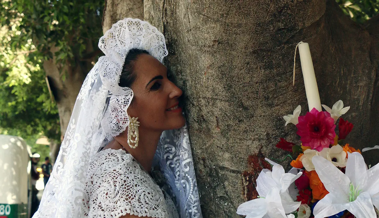 Aktivis lingkungan berpakaian pengantin memeluk dan mencium pohon di San Jacinto Amilpas, Oaxaca, Meksiko, Minggu (25/2). (AFP FOTO/PATRIKIA CASTELLANOS)