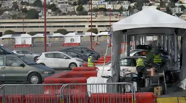 Mobil-mobil menunggu untuk mendapatkan vaksin COVID-19 di pusat vaksinasi drive-thru di City College of San Francisco di San Francisco, Senin (1/2/2021). Ketika pasokan vaksin COVID-19 meningkat, UC San Francisco memperluas upaya vaksinasi kepada mereka yang paling berisiko. (AP Photo/Jeff Chiu)