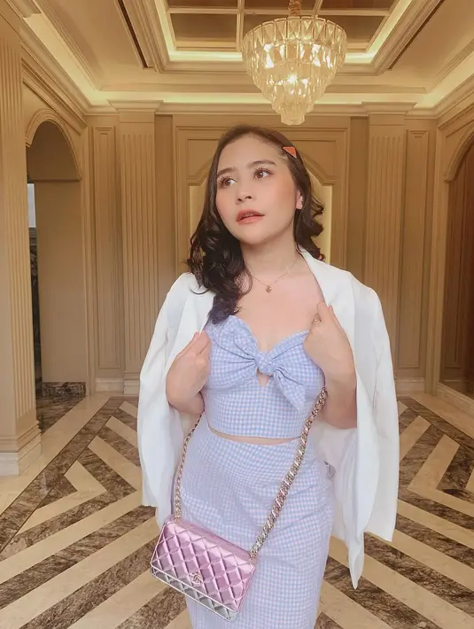 Blazer adalah outfit go-to terbaik yang bisa kamu padu padan kapanpun dengan outfit apapun. Kali ini Prilly mengenakan setelan off-shoulder crop top dengan midi skirt bermotif langham biru yang kemudian dipadunya dengan blazer putih polos dan tas sling bag. Foto: Instagram.