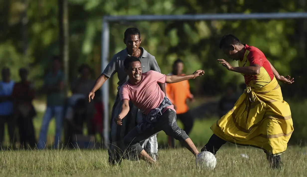 Penduduk desa bermain sepak bola dengan mengenakan sarung saat merayakan HUT ke-74 RI di Blang Pidie provinsi Aceh (17/8/2019). Indonesia merayakan kemerdekaan yang ke-74 dari pemerintahan kolonial Belanda. (AFP Photo/Chaideer Mahyuddin)
