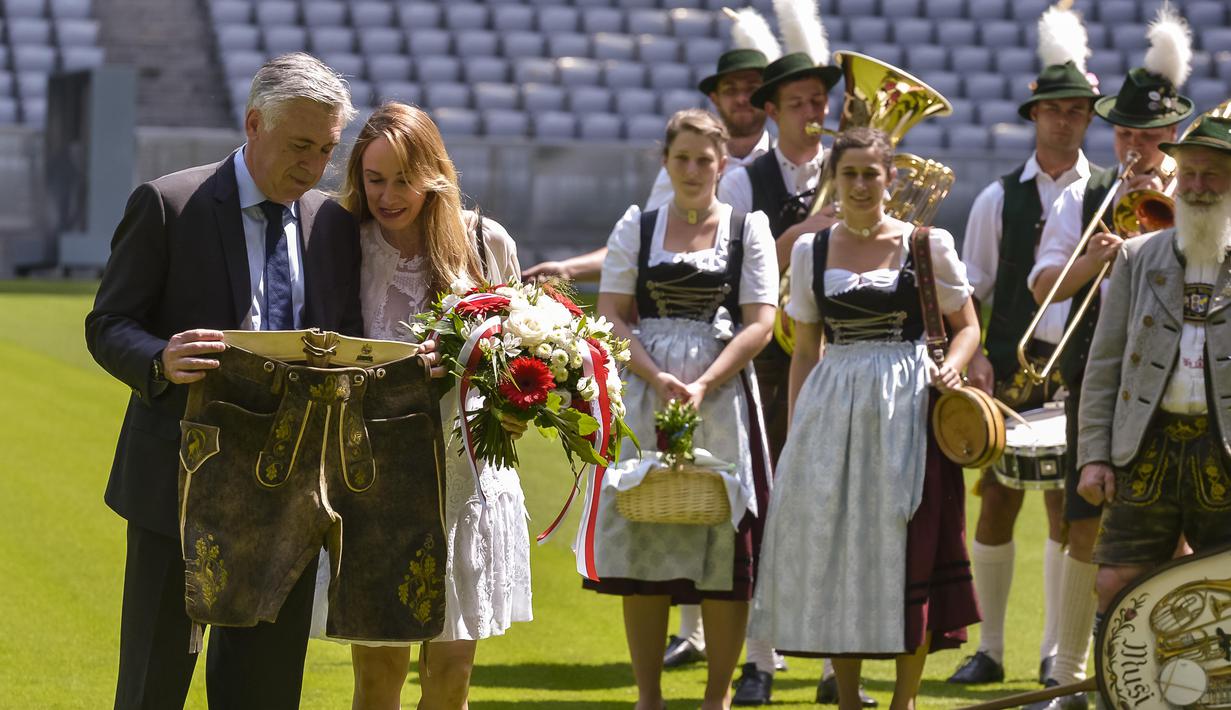 Carlo Ancelotti (kiri) bersama istrinya Mariann melihat celana tradisional Bavaria miliknya pada sesi foto dan perkenalan di Stadion klub FC Bayern Munich, Jerman, (11//7/2016). (AFP/Guenter Schiffmann)