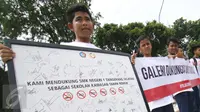 Sejumlah pelajar menunjukan spanduk saat menggelar aksinya di depan Istana Presiden, Jakarta, Sabtu (25/2). Mereka meminta kepada Presiden Jokowi agar sama-sama melawan perusahaan rokoknya yang menargetkan para pelajar. (Liputan6.com/Helmi Afandi)
