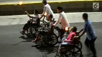 Umat muslim menggunakan kursi roda mengikuti pawai obor menyambut Tahun Baru Islam 1441 H di kawasan Bundaran HI, Jakarta, Sabtu (31/8/2019). Pawai yang diikuti 4000 peserta digelar dalam rangka Jakarta Muharram Festival. (merdeka.com/Imam Bukhori)