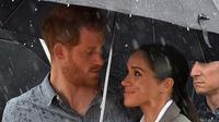 Pangeran Harry dan Meghan Markle menyaksikan tarian suku Aborigin di Victoria Park, Dubbo, Australia, Rabu (17/10/2018). (PETER PARKS / POOL / AFP/Asnida Riani)