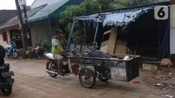 Pengumpul barang bekas berkeliling di Ciledug Indah, Tangerang, Banten, Senin (21/2./2021). Pasca banjir melanda perumahan tersebut menjadi berkah bagi para pengumpul barang rongsok karena banyak barang yang di buang pemilik rumah. (Liputan6.com/Angga Yuniar)