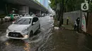 Kendaraan melintasi genangan air di Jalan Gatot Subroto, Jakarta, Kamis (18/2/2021). Hujan deras yang mengguyur wilayah Jakarta menyebabkan terjadinya genangan di beberapa ruas jalan, meski begitu sejauh ini kendaraan masih dapat melintas. (Liputan6.com/Faizal Fanani)