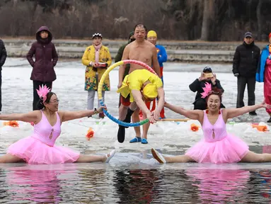 Seorang perenang musim dingin yang mengenakan kostum menyelam ke dalam danau yang sebagian membeku di Shenyang, provinsi Liaoning, China, Selasa (19/2). Mereka percaya berendam di sungai dengan suhu yang ekstrem baik untuk kesehatan. (Photo by STR / AFP)