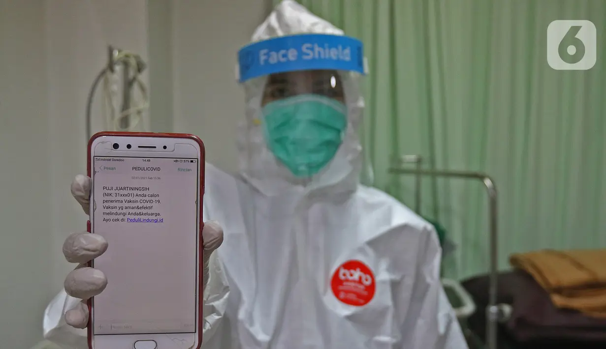 Tenaga kesehatan menunjukkan pesan singkat penerima vaksin COVID-19 di RSIA Tambak, Jakarta, Selasa (5/01/2021). Kementerian Kesehatan mengirimkan Short Message Service (SMS) blast secara serentak kepada penerima vaksin COVID-19 tahap pertama pada Kamis (31/12) lalu. (Liputan6.com/Herman Zakharia)