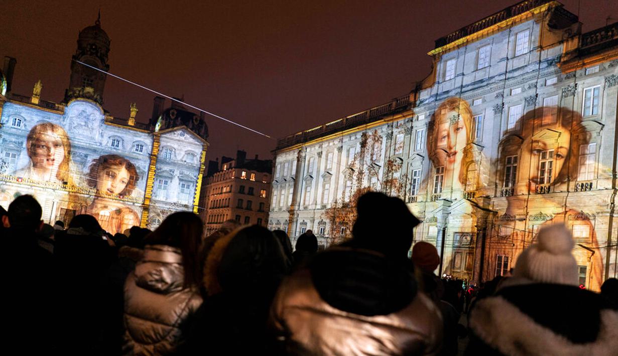 Orang-orang menghadiri pertunjukan cahaya malam di Lyon, Prancis, 8 Desember 2022. Jutaan orang diperkirakan akan menyaksikan acara Festival Cahaya selama empat hari di kota tersebut. (AP Photo/Laurent Cipriani)