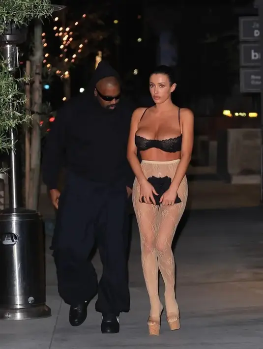 Yang terbaru, Bianca Censori tampil kembali berani dengan outfit uniknya. Ia pergi makan malam bersama Kanye West mengenakan lace bra hitam dipadu lace legging berwarna nude yang memperlihatkan tubuhnya. [Foto: Instagram/alwaysyzy]