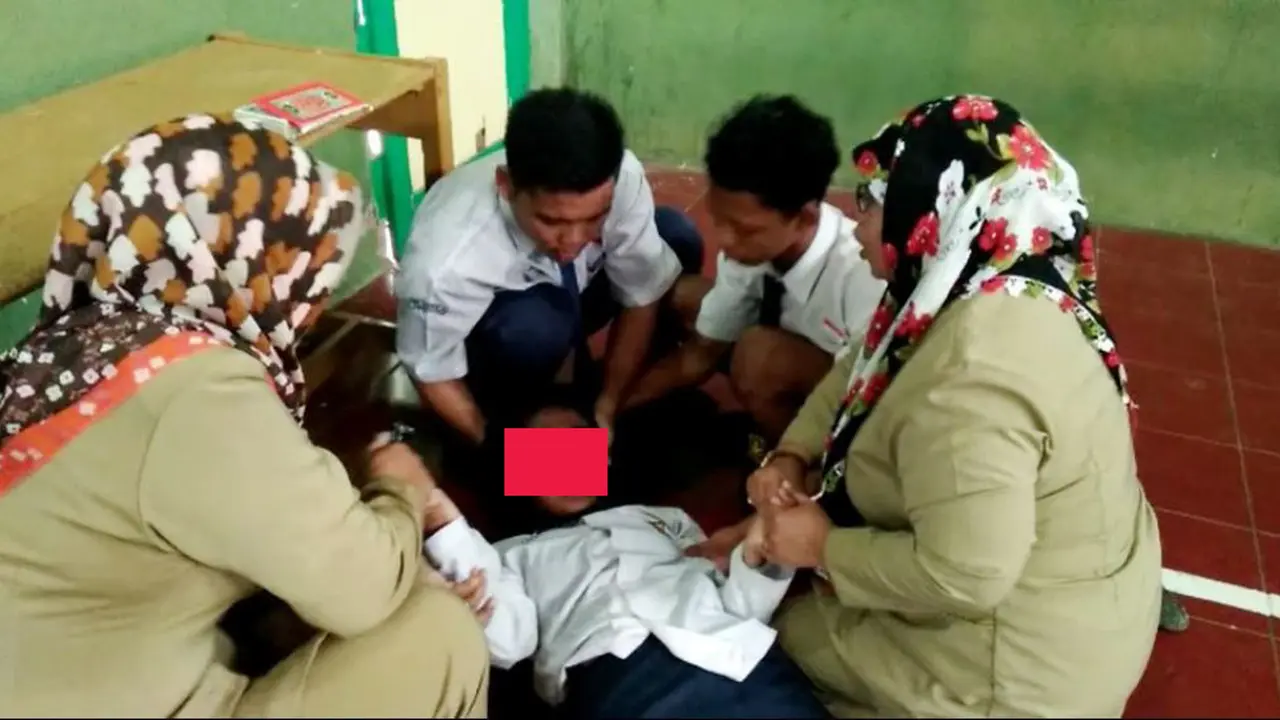 Guru dan siswa berusaha menenangkan siswi yang kesurupan. (Foto: Liputan6.com/Muhamad Ridlo)