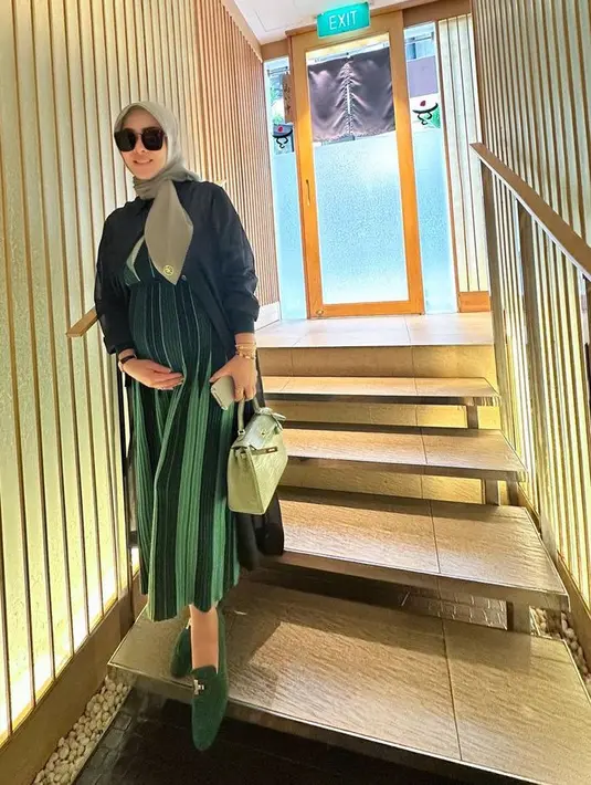 <p>Syahrini tampil serba hijau, sengan dress plisket dipadukan outer jaket serta kerudungnya. Ia membawa tas Hermes dan mengenakan flat shoes hijau emerald. [@princessyahrini]</p>