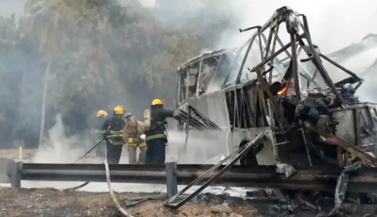 Petugas memadamkan api yang masih tersisa akibat tabrakan antara bus dengan truk pengangkut BBM di Guerrero, Meksiko, Kamis (13/4). Pejabat setempat mengatakan truk tangki membawa 40 ribu liter bensin yang mudah terbakar (HO/Guerrero Civil Protection/AFP)