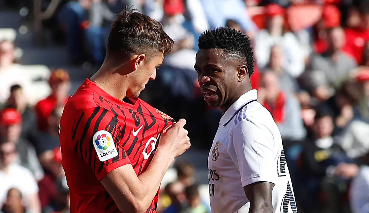 Pemain Real Madrid, Vinicius Junior (kanan) terlihat Adu mulut dengan pemain Real Mallorca Antonio Jose Raillo dalam pertandingan pekan ke-20 La Liga 2022/2023 yang berlangsung di Palma de Mallorca, Minggu (5/2/2023).  (AFP/Jaime Reina)