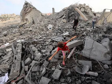 Seorang anak perempuan Palestina mencari jalan di antara reruntuhan bangunan yang dihantam serangan Israel di kamp pengungsi Bureij, Jalur Gaza tengah pada 10 Juli 2025. (Eyad BABA/AFP)