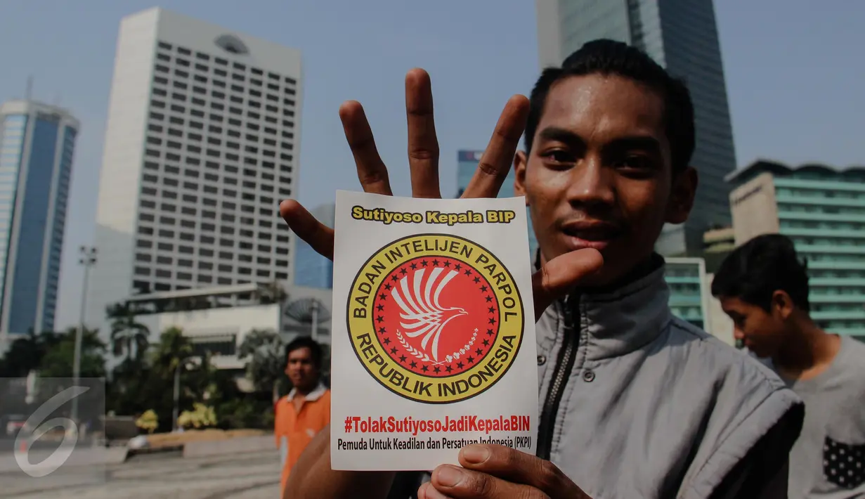 Aktivis Pemuda Untuk Keadilan dan Persatuan Indonesia (PKPI) memperlihatkan stiker yang berisikan penolakan pencalonan Sutiyoso jadi kepala BIN saat aksi damai di Bundaran HI, Jakarta, Minggu (28/6/2015). (Liputan6.com/Faizal Fanani)