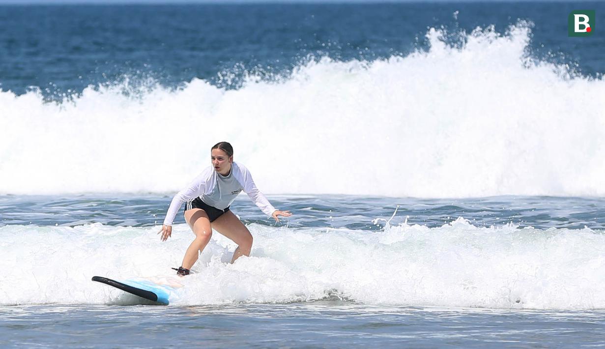 Peselancar tampak asyik menikmati gulungan ombak di Pantai Seminyak Bali. (Bola.com/M iqbal Ichsan)