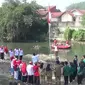 Relawan lingkungan bersama Karang Taruna dan mahasiswa di Kota Bogor, Jawa Barat menggelar upacara pengibaran bendera di Sungai Ciliwung dalam rangka memperingati HUT ke-78 Kemerdekaan RI. (Liputan6.com/Achmad Sudarno)