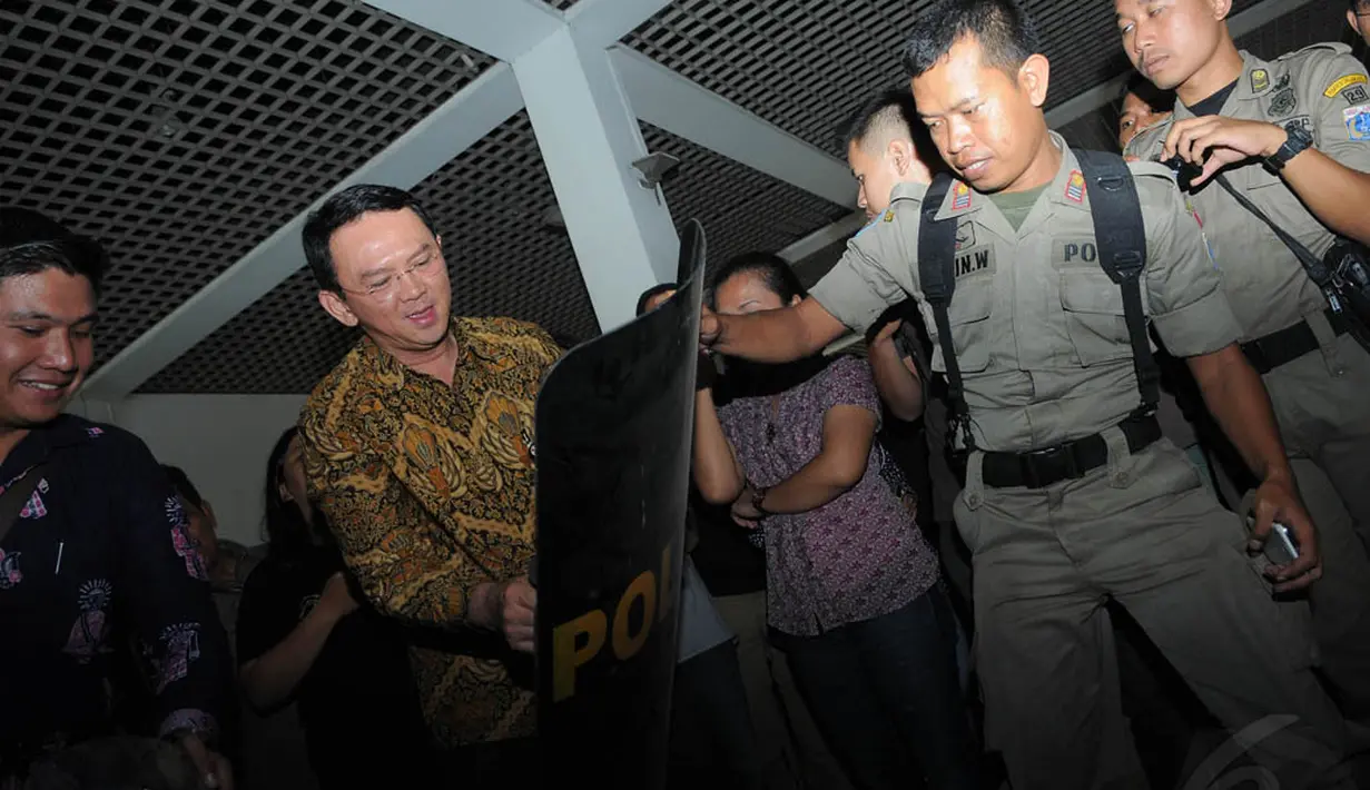Ahok saat mencoba kekuatan perisai yang dipakai Satpol PP, Jakarta, (8/10/14). (Liputan6.com/Herman Zakharia)
