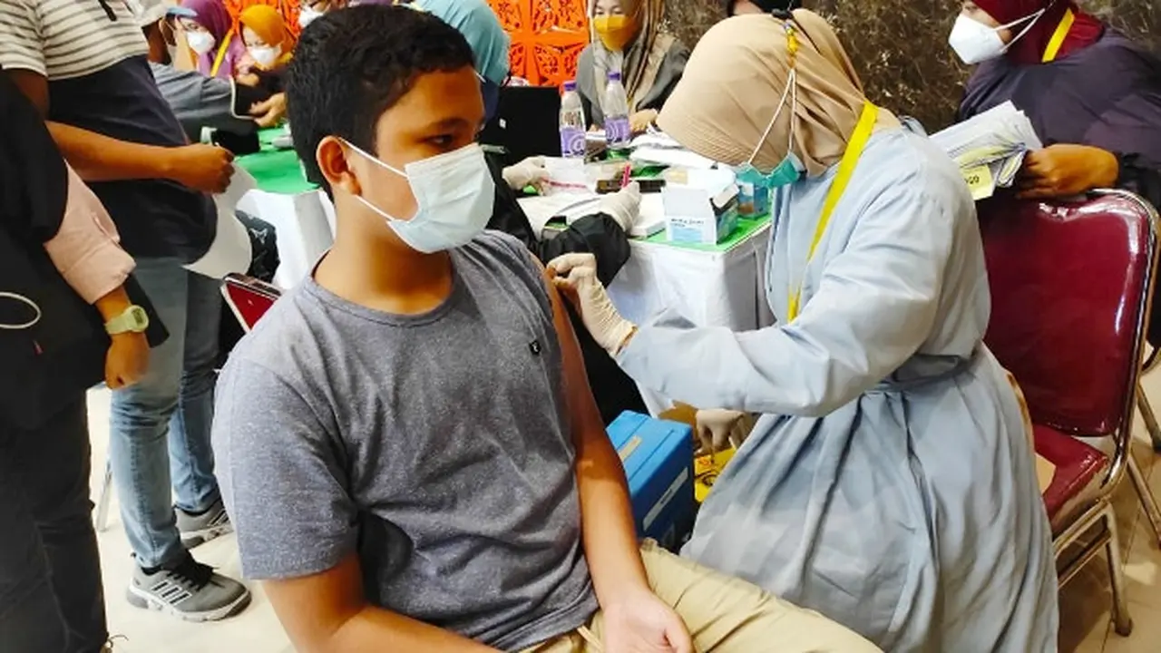 Pemberian vaksin Covid-19 kepada seorang anak di Pekanbaru.
