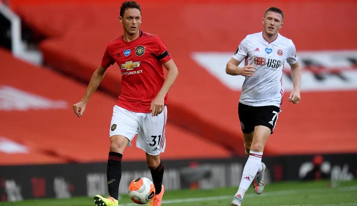 Gelandang Manchester United, Nemanja Matic (kiri) menggiring bola saat bertanding melawan Sheffield United pada pertandingan lanjutan Liga Inggris di Old Trafford di Manchester, Inggris (24/6/2020). MU menang telak 3-0 atas Sheffield United. (Michael Regan/Pool via AP)