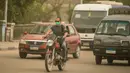 Seorang pria yang mengenakan masker mengendarai sepeda motor di sebuah jalan di Kairo, Mesir, pada 5 April 2020. Mesir pada Sabtu (4/4) melaporkan lima kematian baru akibat infeksi COVID-19, menjadikan total kasus kematian di negara tersebut mencapai 71. (Xinhua/Wu Huiwo)