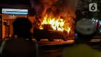 Sebuah mobil terbakar di Jalan Asia Afrika, Jakarta, Kamis (18/3/2021) dinihari. Kobaran api yang melahap mbil jenis minibus bernomor polisi B 1608 SGZ itu menjadi tontonan warga. (Liputan6.com/Johan Tallo)