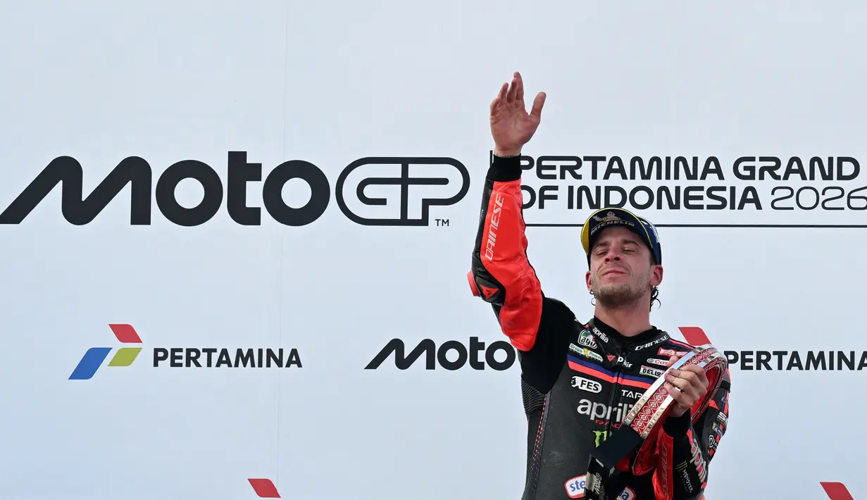 Pembalap Aprilia Racing asal Italia, Marco Bezzecchi, merayakan kemenangan di podium setelah menjuarai balapan MotoGP Indonesia di Sirkuit Internasional Mandalika, Mandalika, Minggu (11/10/2026). (SONNY TUMBELAKA/AFP)