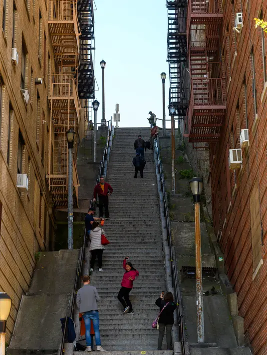 Pengunjung memadati tangga di kawasan Bronx, New York, 23 Oktober 2019. Sejumlah orang mulai mendatangi lokasi tangga yang sudah diberi label Joker Stairs tersebut untuk berfoto meniru adegan ikonik di Film Joker. (Don Emmert / AFP)