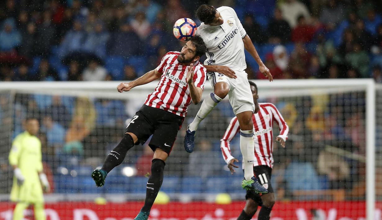 Pemain Real Madrid, Raphael Varane berduel dengan pemain Athletic Bilbao, Raul Garcia pada lanjutan La Liga di Santiago Bernabeu stadium, Madrid, senin (23/10/16) dini hari WIB. (AP/Daniel Ochoa de Olza)