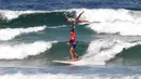 Gerakan atlet AS, Kalani Vierra dan Krystl Apeles, menarik penonton saat beraksi dalam Kejuaraan Internasional Surfing Tandem di Biscarrosse, Prancis, (23/7/2016). (AFP/Mehdi Fedouach)