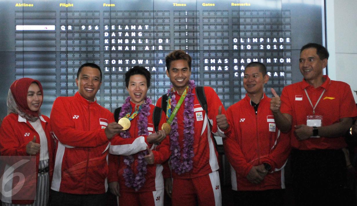 Ganda campuran Indonesia, Lilyana NatsirdanTontowi Ahmad berfoto bersama saat tiba di Bandara Soekarno Hatta, Banten, Selasa (23/8/2016). Tontowi Ahmad/Lilyana Natsir berhasil meraih emas olimpiade Rio 2016 di Brasil. (Liputan6.com/HelmiFithriansyah)
