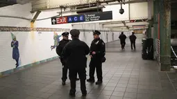 Aparat kepolisian berjaga di lorong stasiun kereta bawah tanah dekat lokasi teror bom pipa di New York City, Senin (11/12). Imigran asal Bangladesh, Akayed Ullah (27), menjadi tersangka pelaku ledakan. (JOHN MOORE / GETTY IMAGES NORTH AMERICA / AFP)