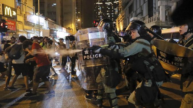 Polisi Hong Kong menembakan gas air mata ke kerumunan demonstran (AP/Kin Cheung)