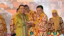 Ketua Bawaslu, Abhan menyerahkan potongan tumpeng kepada Ketua Komisi II DPR RI, Zainuddin Amali pada perayaan HUT 1 Dasawarsa Bawaslu di Jakarta, Senin (9/4). (Liputan6.com/Helmi Fithriansyah)
