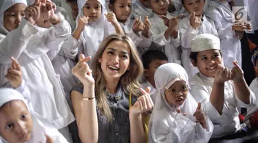 Artis Jessica Iskandar bersama anak-anak rumah singgah Yayasan Bina Anak Pertiwi, Jakarta, Selasa (12/6). Jessica bercerita bahwa dirinya telah mengadopsi tiga anak berkebutuhan khusus dari yayasan yang berbeda. (Liputan6.com/Faizal Fanani)